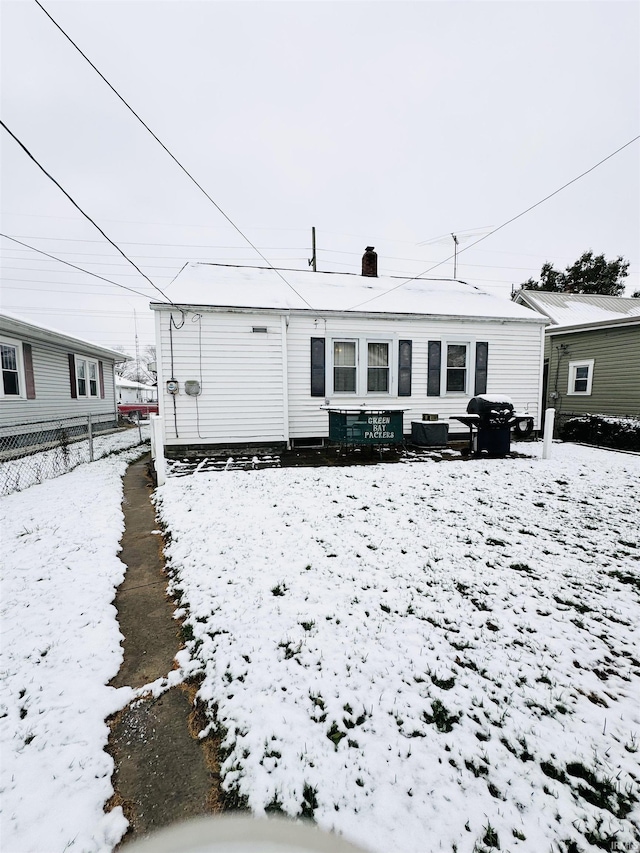 view of snow covered rear of property