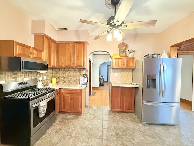 kitchen with light tile patterned floors, stainless steel appliances, tasteful backsplash, and ceiling fan