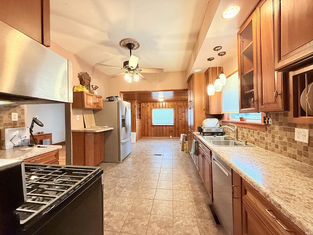 kitchen featuring hanging light fixtures, sink, ceiling fan, appliances with stainless steel finishes, and tasteful backsplash