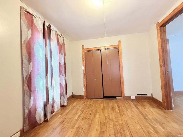 unfurnished bedroom featuring light hardwood / wood-style floors and a closet