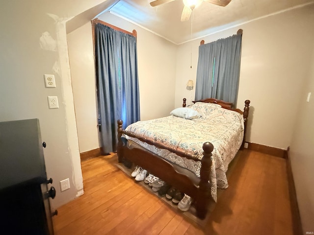 bedroom featuring hardwood / wood-style floors, ceiling fan, and crown molding