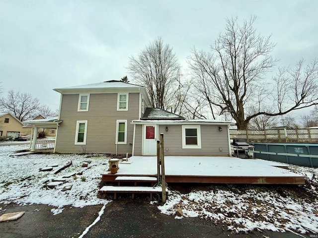 snow covered rear of property featuring a wooden deck