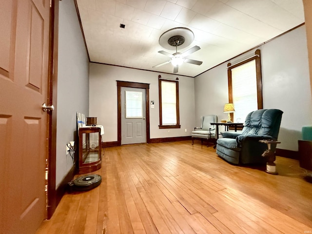 sitting room with ceiling fan, crown molding, and light hardwood / wood-style flooring