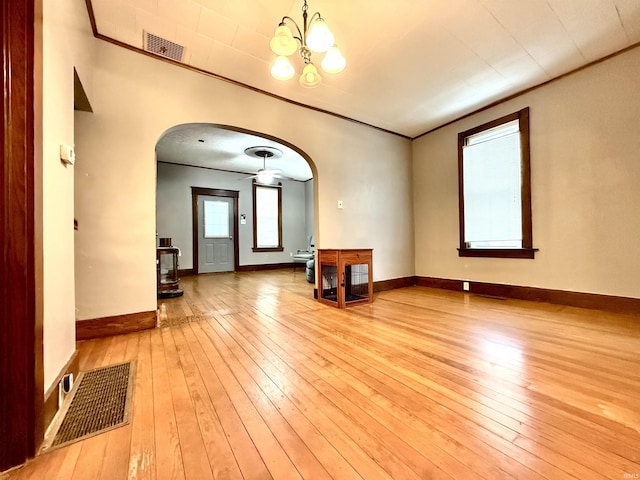 unfurnished room with light hardwood / wood-style flooring, ceiling fan with notable chandelier, and ornamental molding