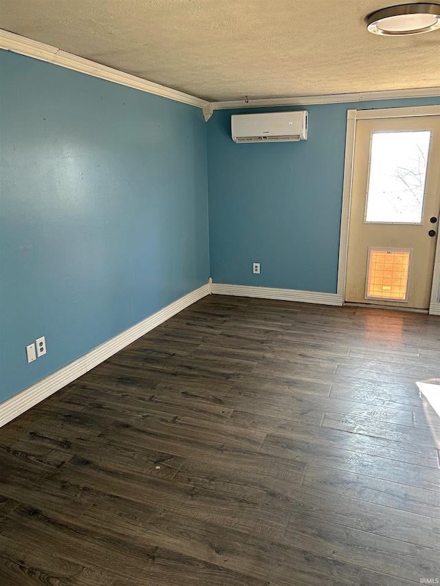 empty room featuring a wall mounted AC, crown molding, dark hardwood / wood-style flooring, and a textured ceiling