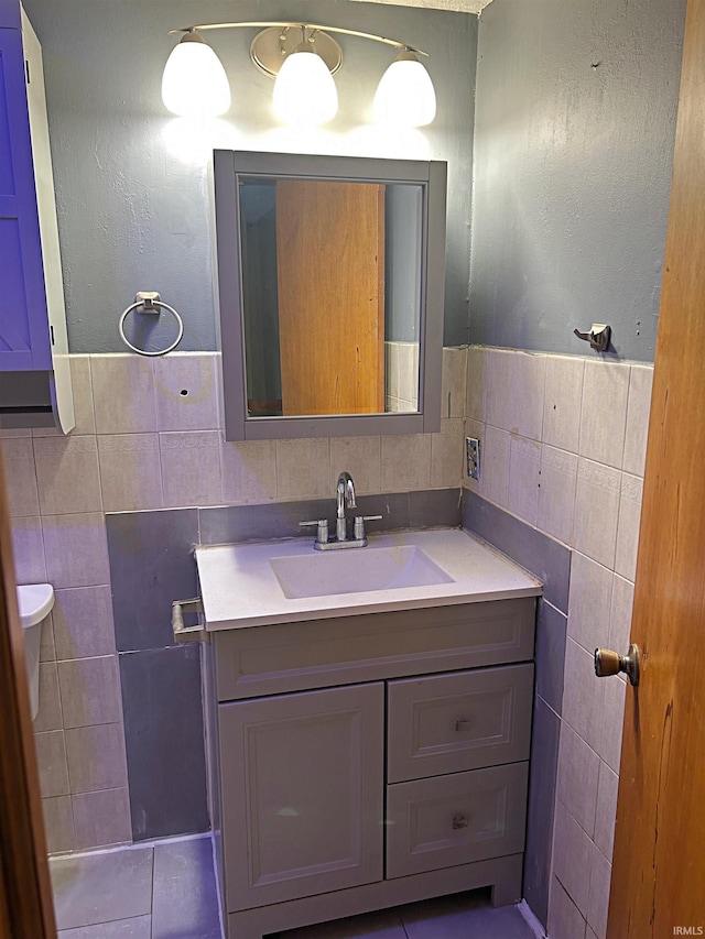 bathroom featuring tile patterned flooring, vanity, tile walls, and tasteful backsplash