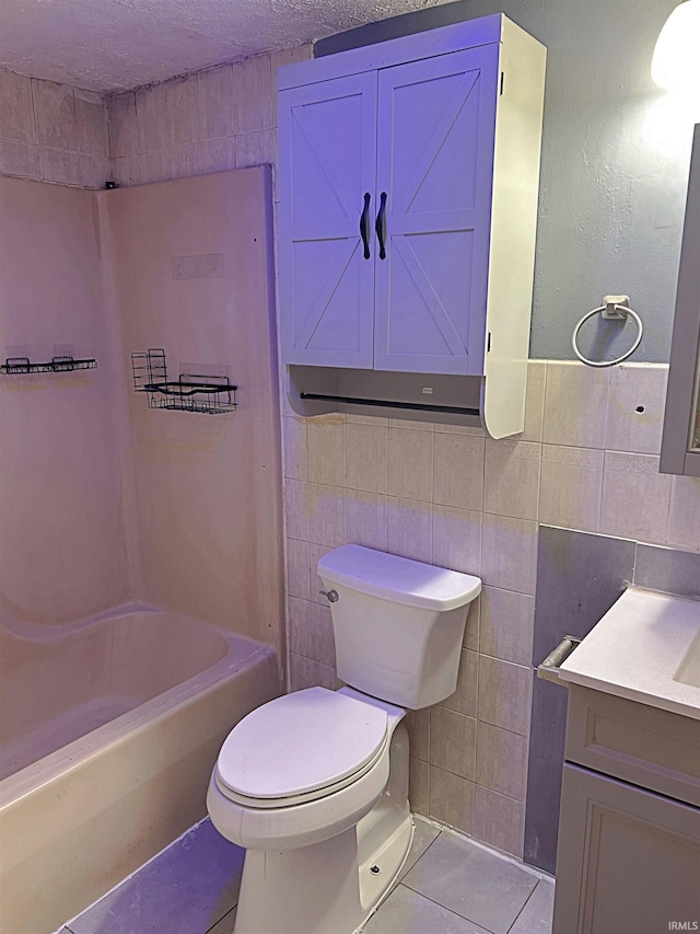 bathroom featuring tile walls, tile patterned flooring, a textured ceiling, and toilet