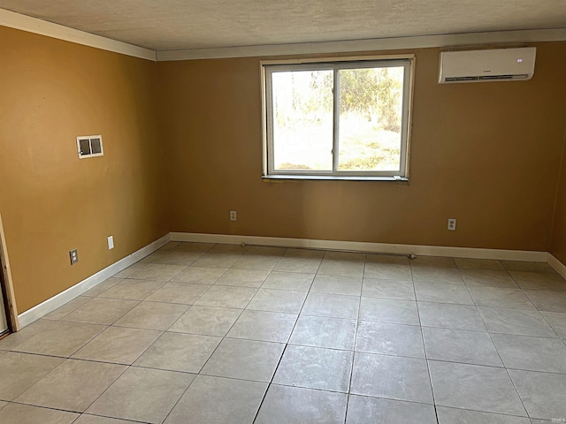 tiled spare room featuring a textured ceiling and a wall mounted AC