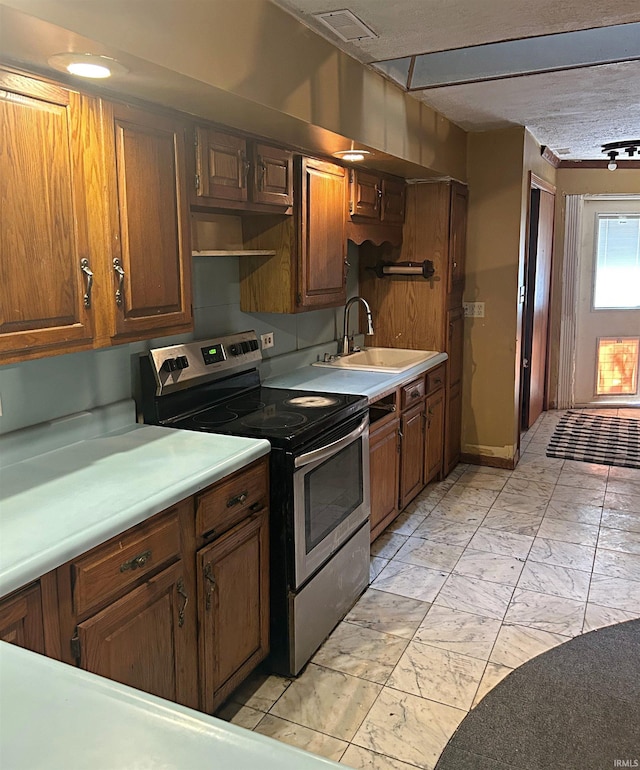 kitchen featuring stainless steel electric stove, sink, and a textured ceiling