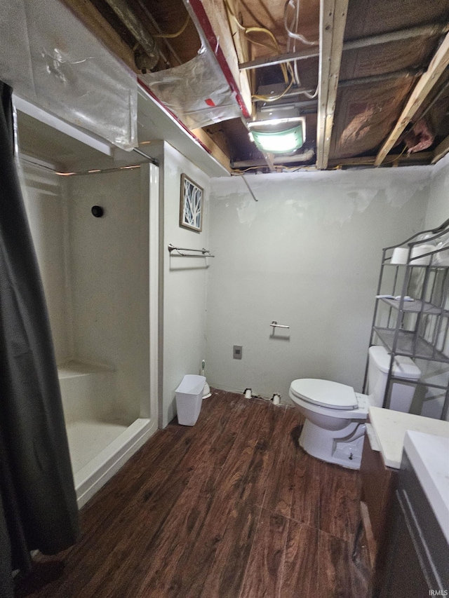 bathroom with toilet, vanity, wood-type flooring, and walk in shower