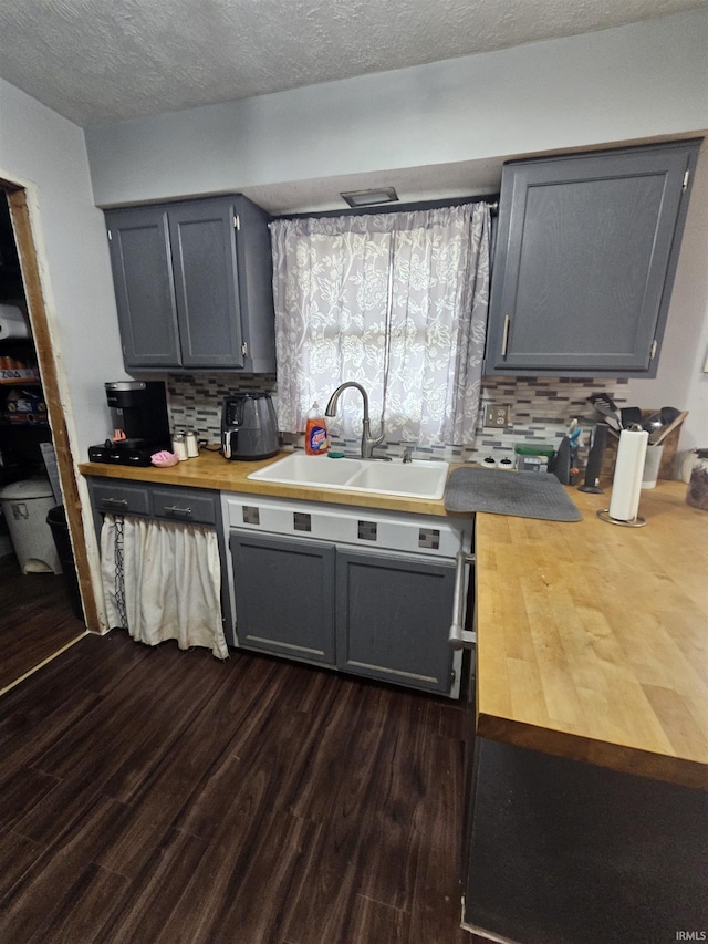 kitchen featuring gray cabinetry, decorative backsplash, and sink