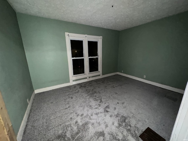 carpeted empty room with a textured ceiling