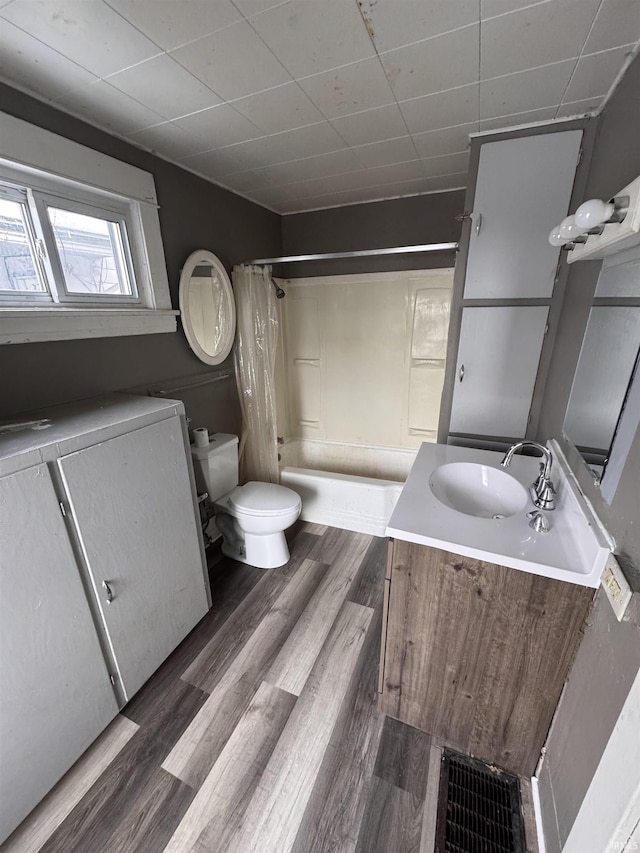 full bathroom with vanity, toilet, wood-type flooring, and shower / tub combo with curtain