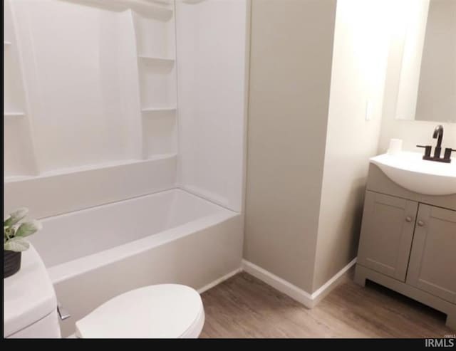 full bathroom with bathing tub / shower combination, hardwood / wood-style floors, vanity, and toilet