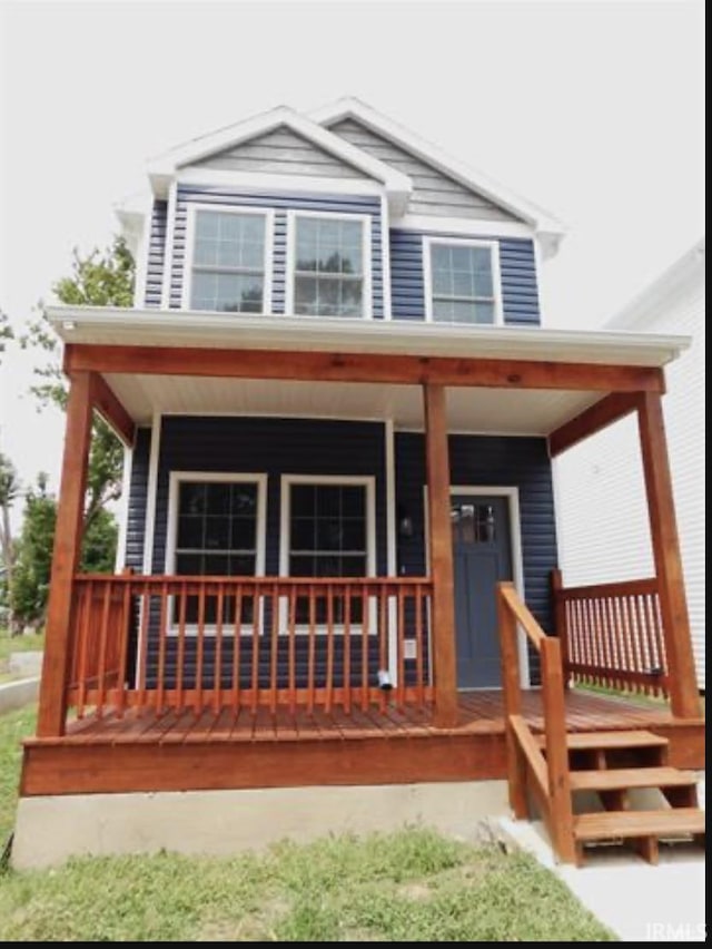 rear view of property featuring covered porch