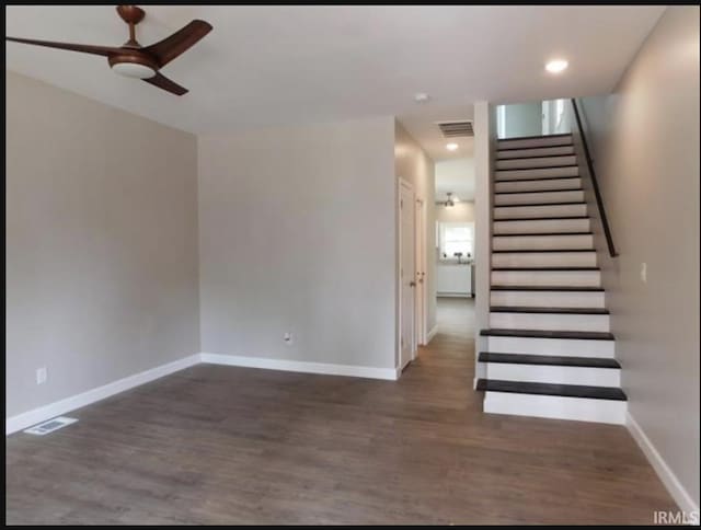 stairs featuring ceiling fan and hardwood / wood-style flooring