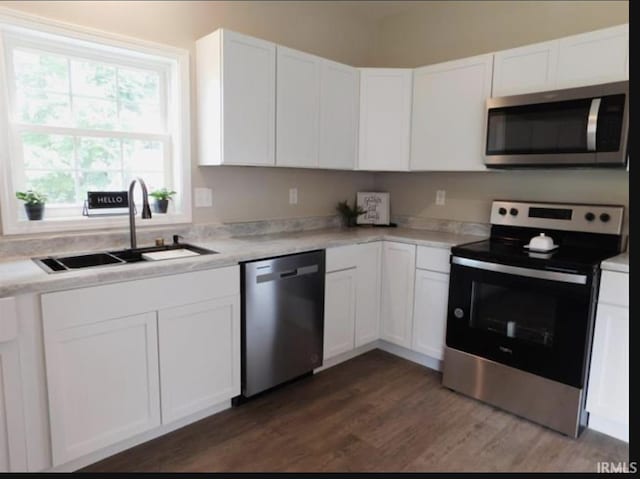 kitchen featuring stainless steel appliances, dark hardwood / wood-style flooring, white cabinets, and sink