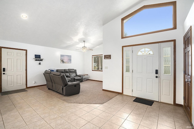 tiled foyer featuring a textured ceiling, high vaulted ceiling, and ceiling fan