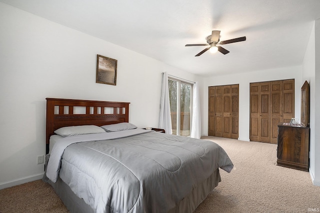 carpeted bedroom featuring ceiling fan and multiple closets