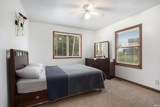 bedroom featuring ceiling fan, carpet floors, and a textured ceiling