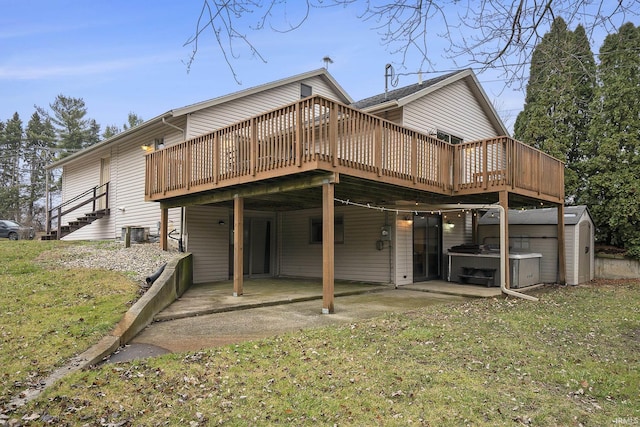 back of property featuring a storage unit, a lawn, a patio area, and a wooden deck