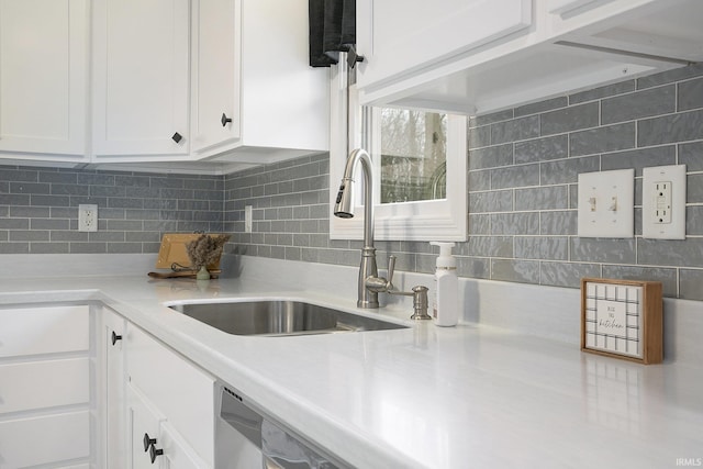 kitchen with decorative backsplash, white cabinetry, and sink