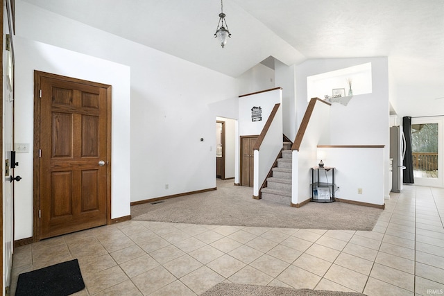 carpeted foyer entrance featuring vaulted ceiling