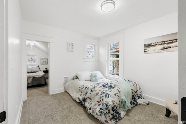 carpeted bedroom with lofted ceiling