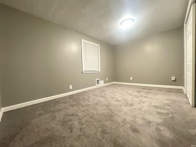 unfurnished room featuring carpet flooring and a textured ceiling