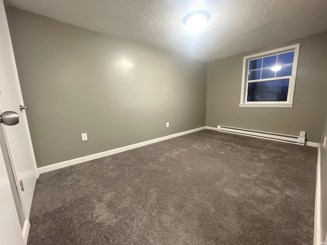 carpeted spare room featuring a textured ceiling and a baseboard heating unit