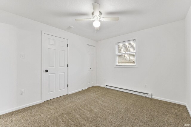 carpeted empty room with baseboard heating and ceiling fan