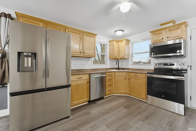 kitchen with dark hardwood / wood-style floors, sink, light stone countertops, and stainless steel appliances