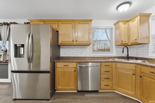 kitchen with appliances with stainless steel finishes, tasteful backsplash, sink, light brown cabinets, and dark hardwood / wood-style floors