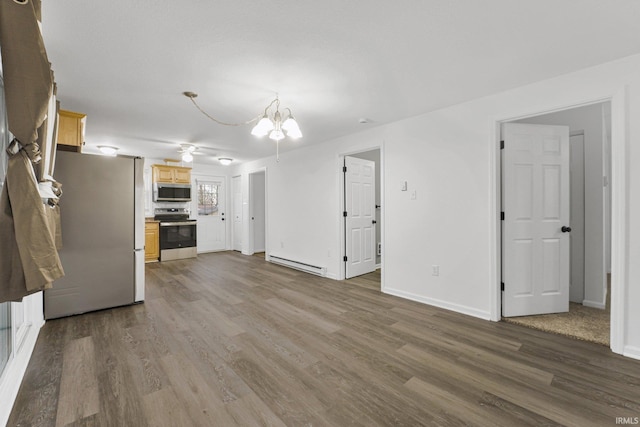 unfurnished living room featuring hardwood / wood-style floors, a baseboard radiator, and a notable chandelier