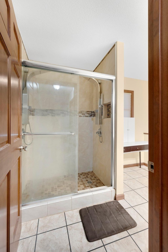 bathroom with tile patterned flooring and an enclosed shower