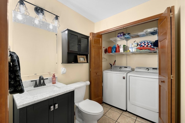 bathroom featuring washer and clothes dryer, tile patterned flooring, toilet, and vanity