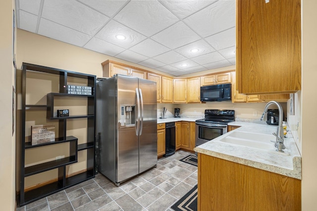 kitchen with a paneled ceiling, sink, light tile patterned floors, and stainless steel appliances