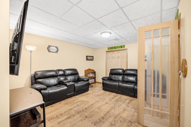 living room featuring a drop ceiling and wood-type flooring