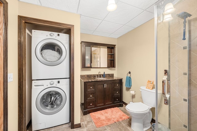 laundry area with stacked washer and dryer, light tile patterned floors, and sink