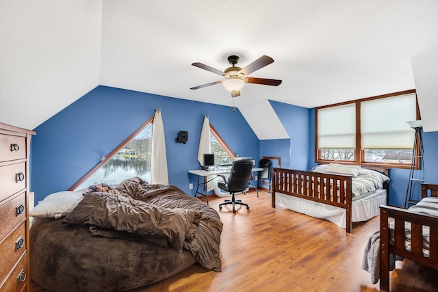 bedroom featuring hardwood / wood-style floors, a textured ceiling, ceiling fan, and lofted ceiling