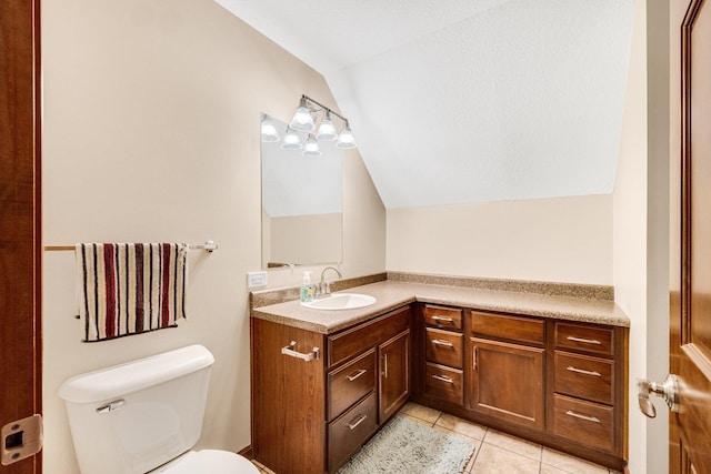 bathroom featuring tile patterned floors, vanity, toilet, and lofted ceiling