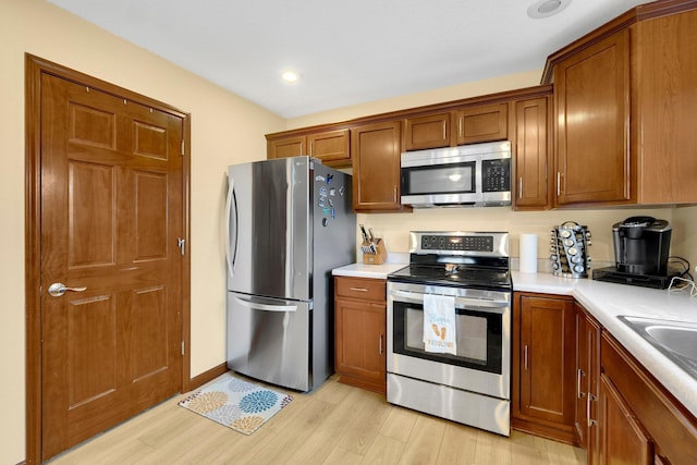 kitchen with light hardwood / wood-style floors, sink, and appliances with stainless steel finishes