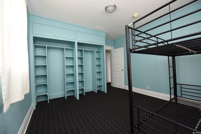 unfurnished bedroom featuring a closet and dark colored carpet