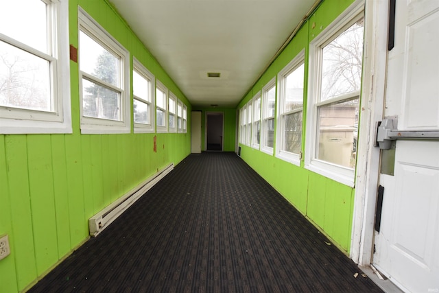 unfurnished sunroom featuring plenty of natural light and baseboard heating