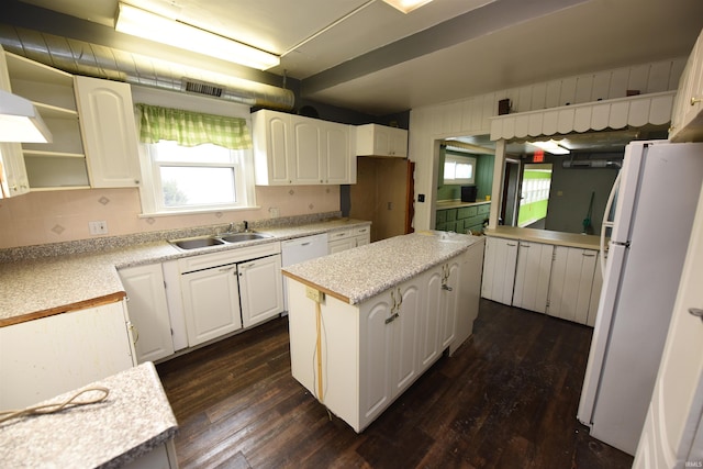 kitchen with white appliances, a kitchen island, sink, dark hardwood / wood-style floors, and white cabinetry