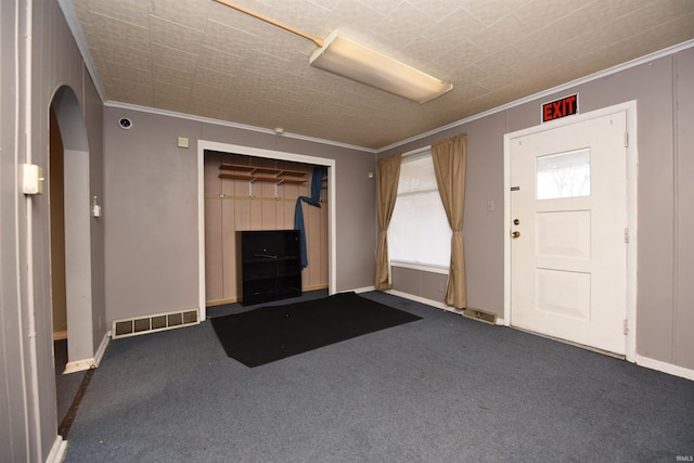 carpeted entrance foyer with crown molding