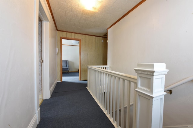 corridor with crown molding, carpet floors, and wood walls