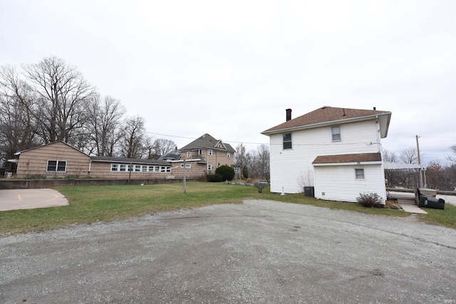 view of property exterior featuring a lawn and central AC unit