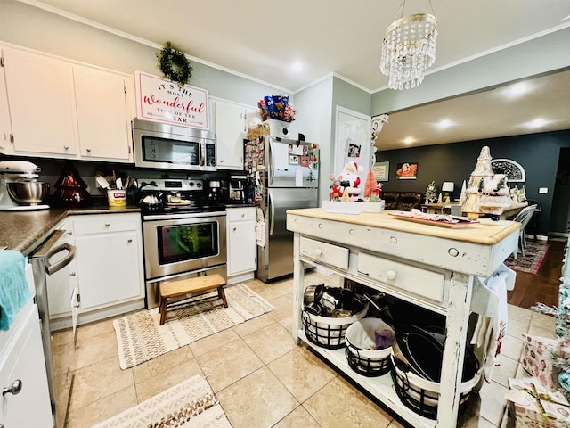 kitchen featuring white cabinets, appliances with stainless steel finishes, light tile patterned floors, and pendant lighting