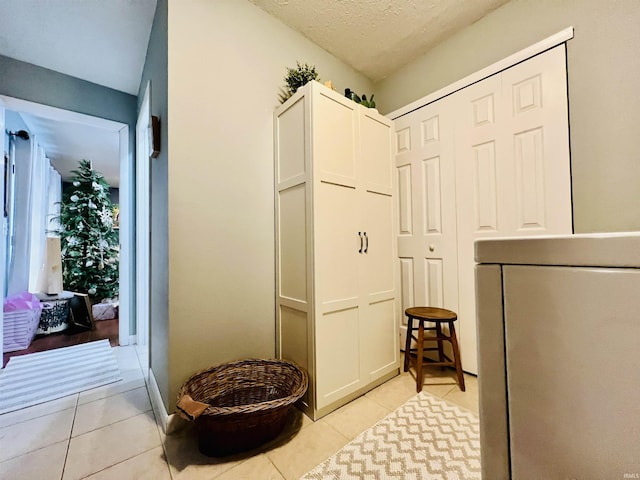 interior space featuring tile patterned flooring, a textured ceiling, and washer / clothes dryer